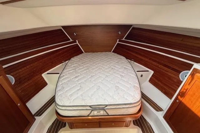Naut On Call Yacht Photos Pics 2016 Back Cove 34 interior cabin with wooden paneling and a comfortable bed.