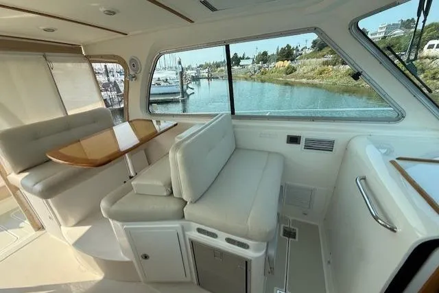 Naut On Call Yacht Photos Pics Interior of 2016 Back Cove 34 yacht with seating and table, overlooking marina.