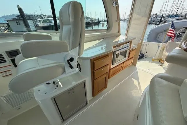 Naut On Call Yacht Photos Pics 2016 Back Cove 34 yacht interior with helm seat, kitchenette, and marina view.