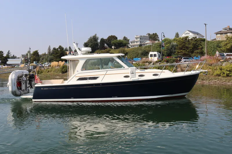 Naut On Call Yacht Photos Pics 2016 Back Cove 34 boat cruising on a calm waterway near a scenic shoreline.