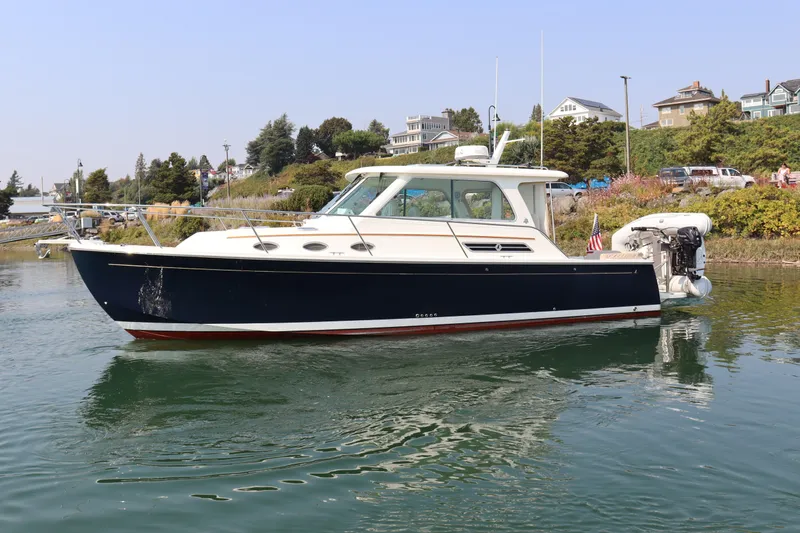Naut On Call Yacht Photos Pics 2016 Back Cove 34 boat on calm water near a scenic shoreline.
