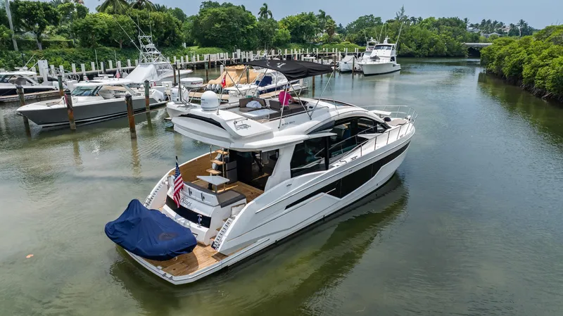 Bikini Blues Yacht Photos Pics 2017 Galeon 510 Sky yacht docked in a serene marina with lush greenery.