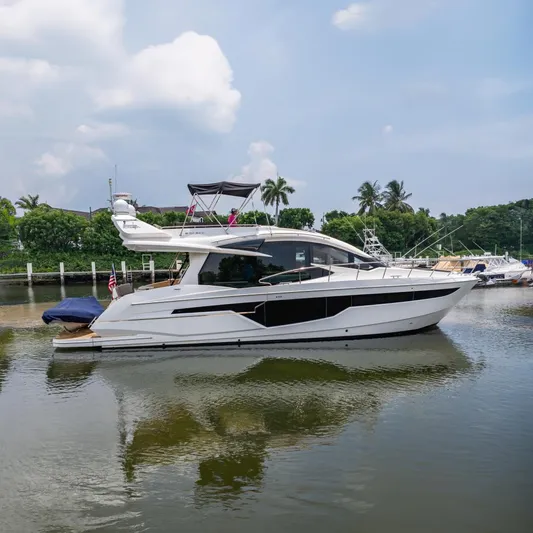 Bikini Blues Yacht Photos Pics 2017 Galeon 510 Sky yacht on calm water, surrounded by lush greenery and palm trees.