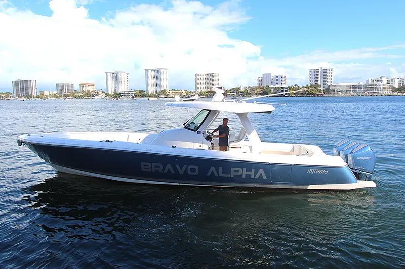"alpha Bravo" Yacht Photos Pics 2022 Intrepid 375 Nomad SE boat cruising on water with city skyline in background.