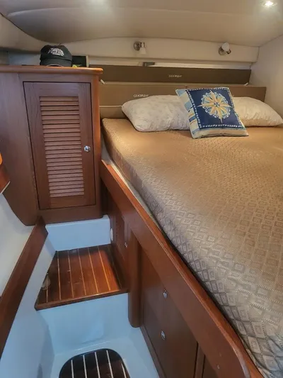 Yacht Photos Pics Cozy cabin interior of 2005 Glacier Bay 3480 Ocean Runner with wooden accents and bedding.