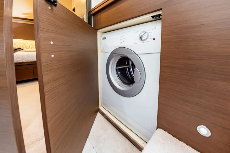 Docked Wages Yacht Photos Pics Washing machine inside 2013 Marquis 63 Sport Yacht, wooden cabinet door open.