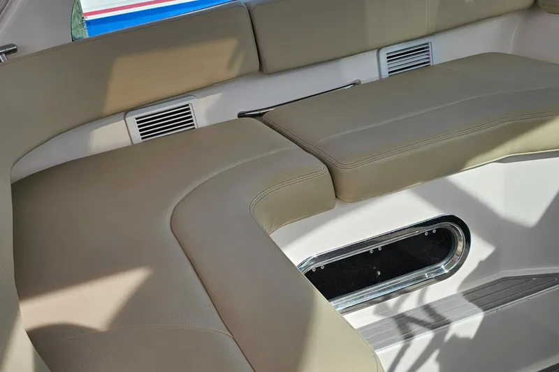  Yacht Photos Pics Interior seating of 2016 Pursuit OS 385 Offshore boat, featuring beige cushions and a window.