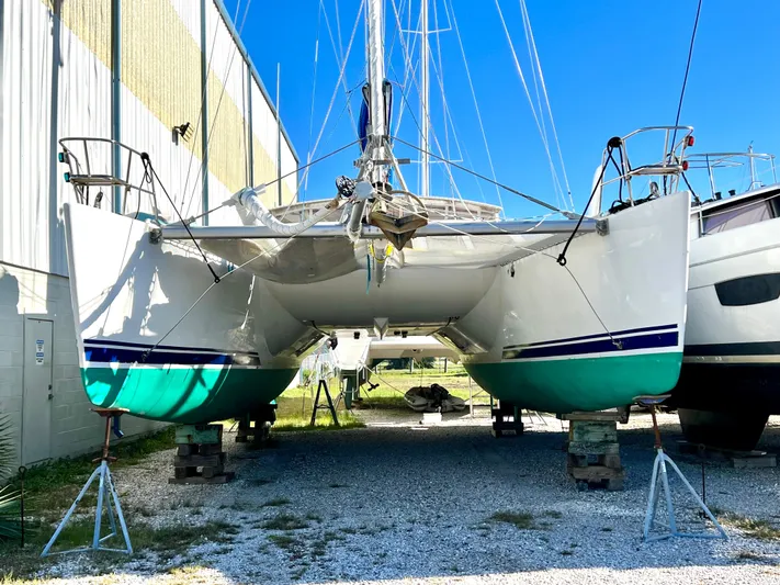 Trebuchet Yacht Photos Pics Catamaran Switch 51, 2000 model, docked on land, vibrant turquoise hull.