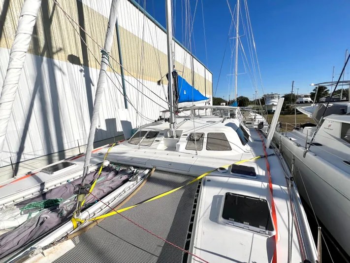 Trebuchet Yacht Photos Pics Sailboat Switch 51, year 2000, docked beside a building under clear blue sky.