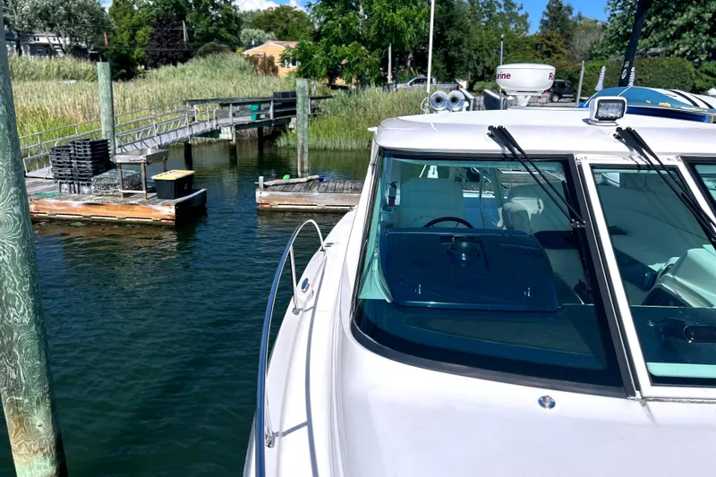  Yacht Photos Pics 2008 Tiara Yachts 3500 Sovran docked near a wooden pier, surrounded by greenery.