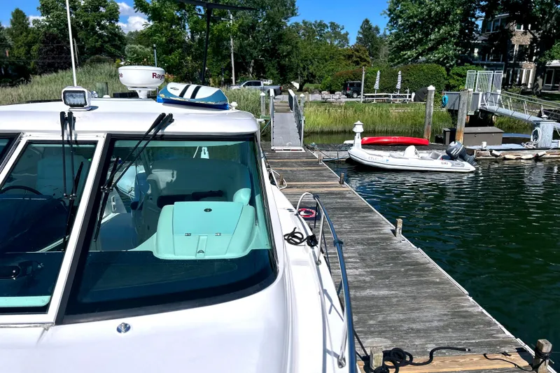  Yacht Photos Pics 2008 Tiara Yachts 3500 Sovran docked, with a small boat nearby on a sunny day.