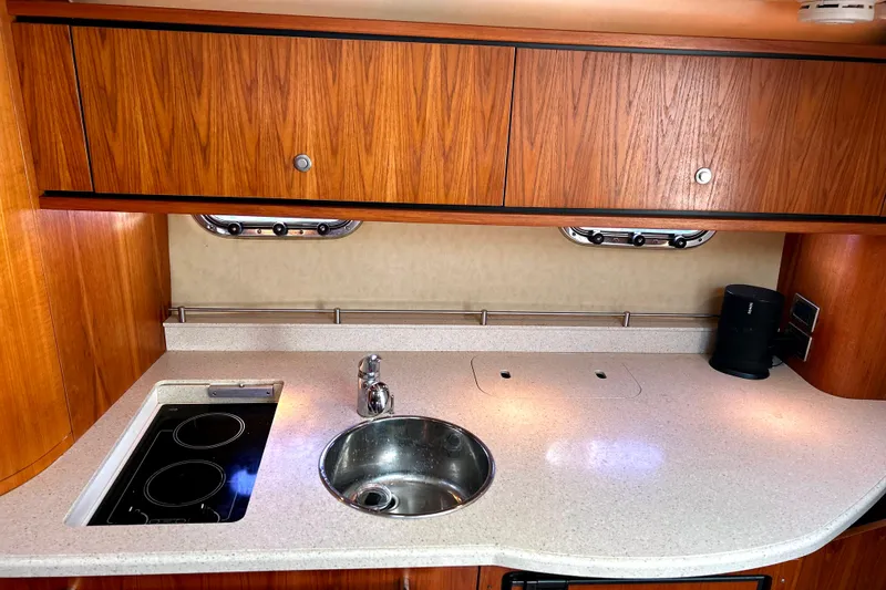  Yacht Photos Pics 2008 Tiara Yachts 3500 Sovran galley with wood cabinets, sink, and stovetop.