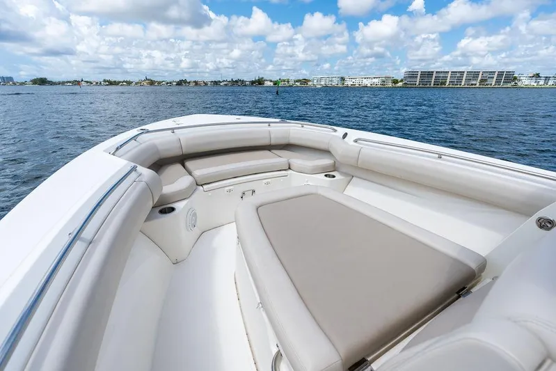 Zoom Yacht Photos Pics 2022 Boston Whaler 280 Outrage boat interior with cushioned seating, on a sunny day.
