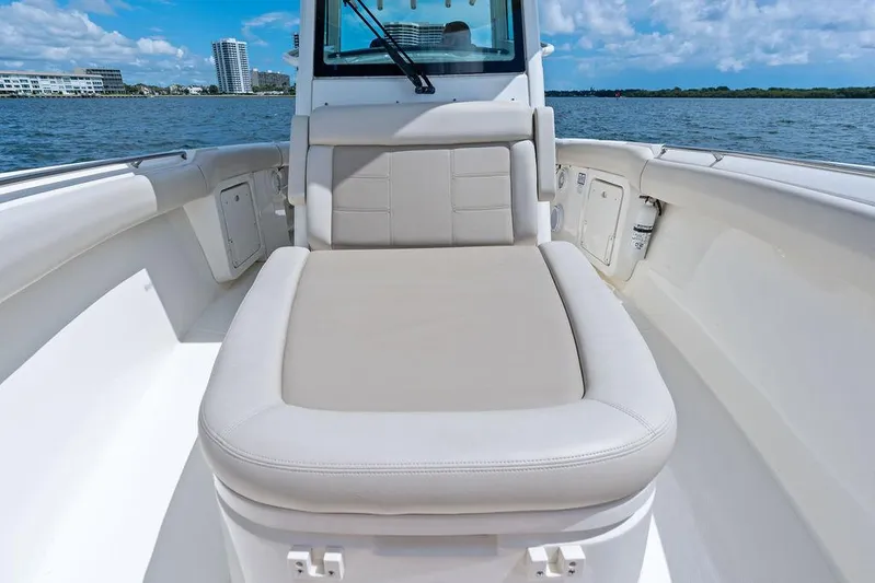 Zoom Yacht Photos Pics 2022 Boston Whaler 280 Outrage boat interior with cushioned seating, on a sunny day.