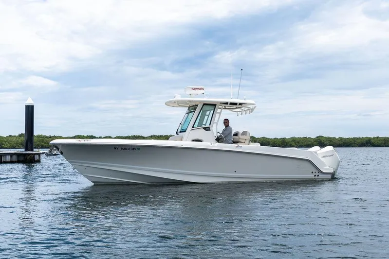 Zoom Yacht Photos Pics 2022 Boston Whaler 280 Outrage boat on water, with clear sky background.