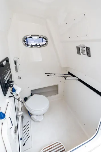 Zoom Yacht Photos Pics 2022 Boston Whaler 280 Outrage interior cabin with toilet and fishing rod storage.