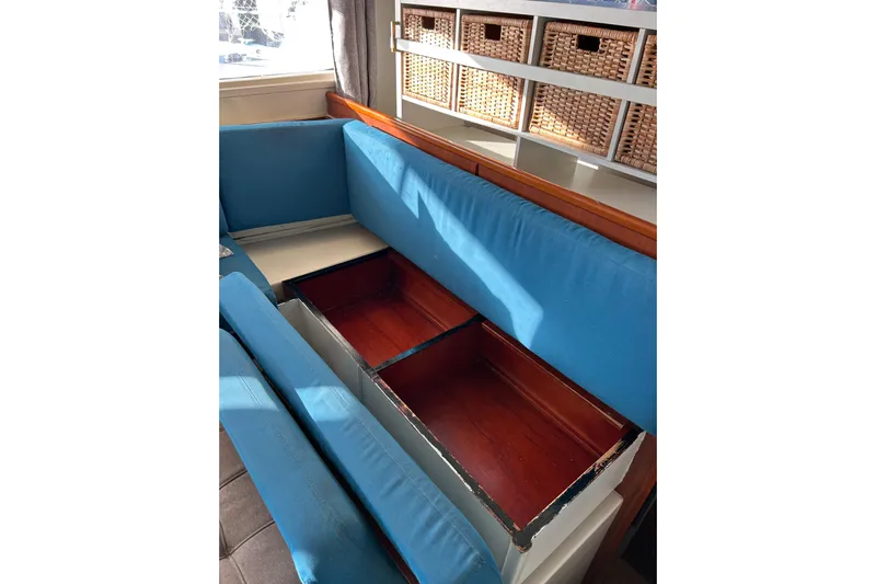  Yacht Photos Pics Interior of 2013 Leopard 48 yacht with blue cushioned seating and storage compartments.