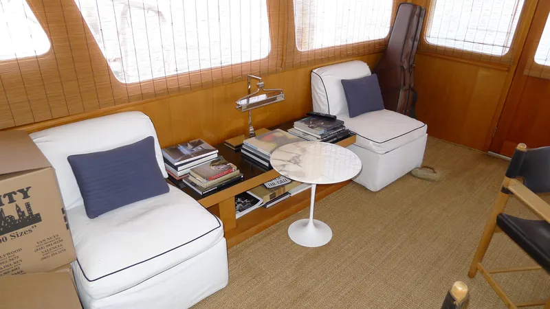 Dakota Yacht Photos Pics Interior of 1953 De Vries Lentsch 68 Motoryacht with white seating and books.