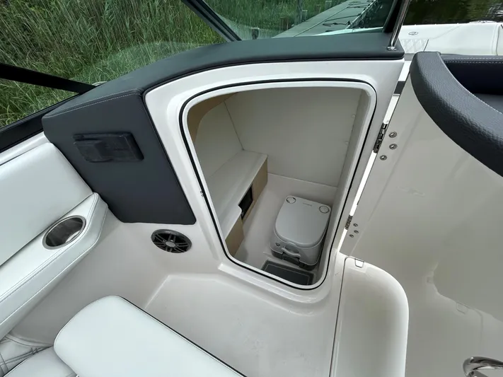  Yacht Photos Pics 2026 Regal LX4 boat interior with compact toilet and seating area.