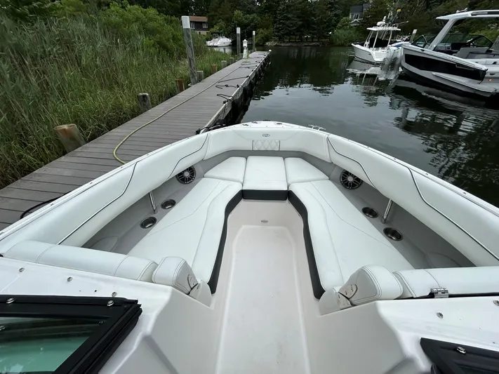  Yacht Photos Pics 2026 Regal LX4 boat interior with white seating, docked by a wooden pier.