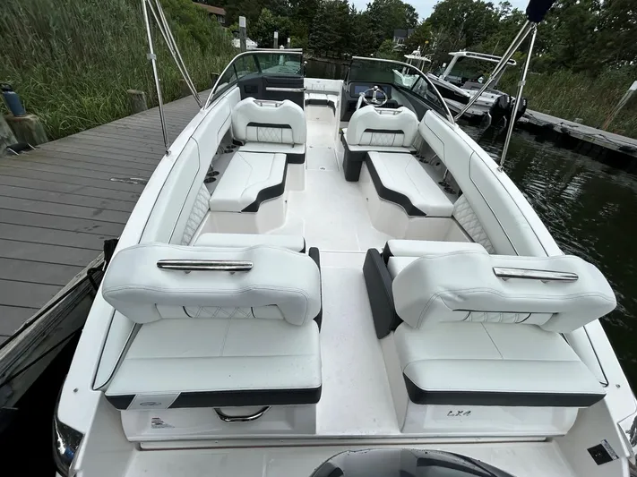  Yacht Photos Pics 2026 Regal LX4 boat with white seating, docked by a wooden pier.