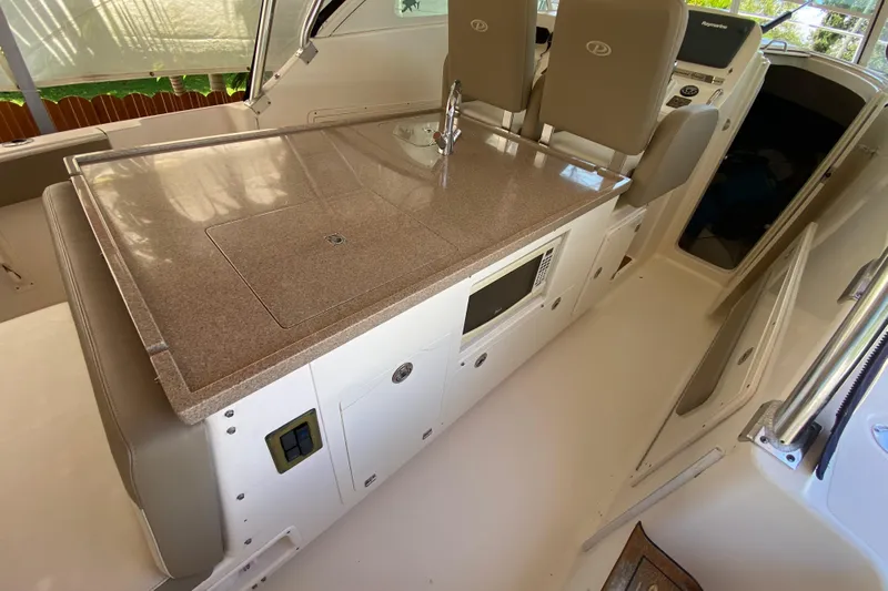  Yacht Photos Pics 2006 Pursuit 3480 Drummond Island Runner interior with kitchenette and seating area.