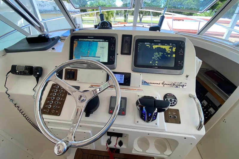  Yacht Photos Pics Helm of 2006 Pursuit 3480 Drummond Island Runner with navigation screens and controls.