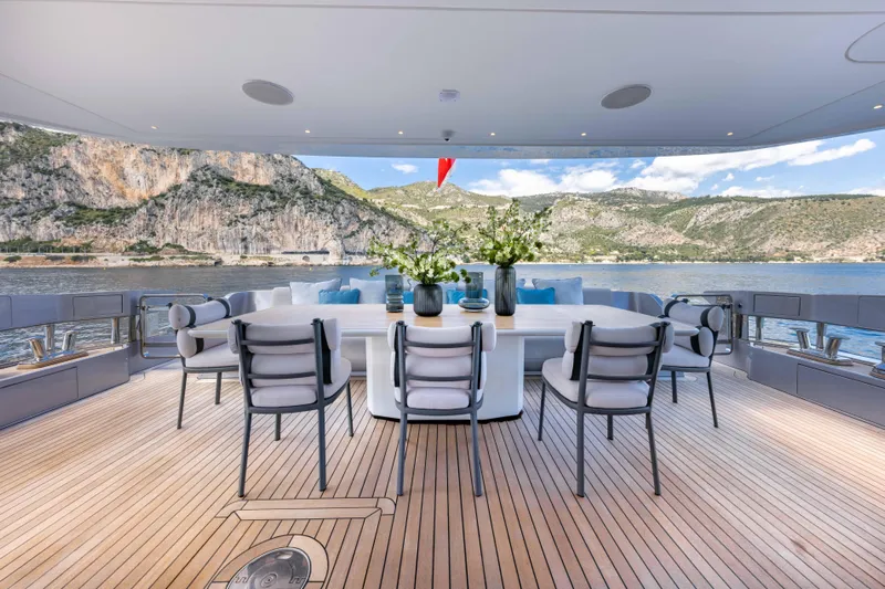 Ocean One Yacht Photos Pics Luxurious Azimut Grande 36M yacht deck with elegant dining area, scenic ocean and mountain views.