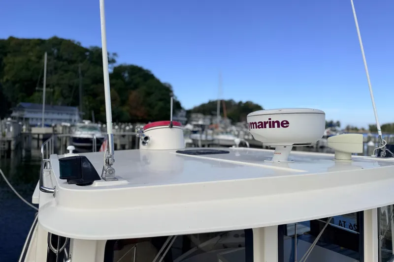 Nomad Yacht Photos Pics Nordic Tug 37 (2000) with radar equipment, docked in a marina under clear blue sky.