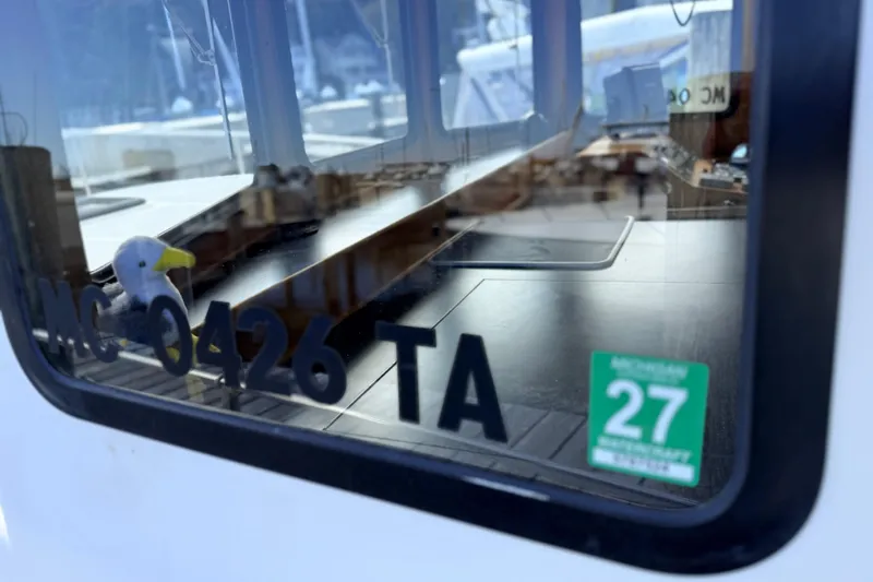 Nomad Yacht Photos Pics Window view of a 2000 Nordic Tug 37 with registration and inspection sticker.