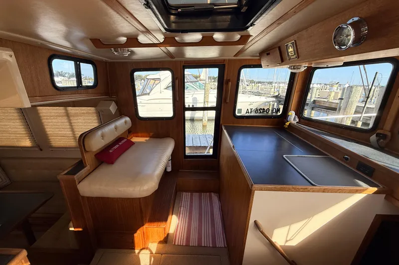 Nomad Yacht Photos Pics Cozy interior of a 2000 Nordic Tug 37, featuring seating and a compact kitchen area.
