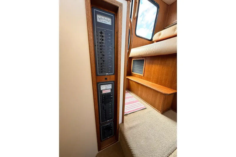 Nomad Yacht Photos Pics Electrical panel inside a 2000 Nordic Tug 37 boat, featuring wood accents and a window.