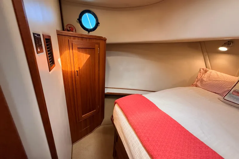Nomad Yacht Photos Pics Cozy cabin interior of 2000 Nordic Tug 37 with wood accents and porthole.
