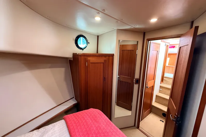 Nomad Yacht Photos Pics Cozy cabin interior of 2000 Nordic Tug 37 with wood accents and porthole window.