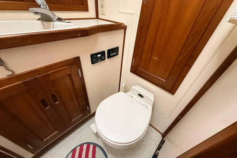 Nomad Yacht Photos Pics Nordic Tug 37 (2000) bathroom with wooden cabinetry and modern fixtures.