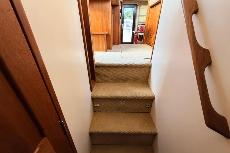 Nomad Yacht Photos Pics Interior stairs of 2000 Nordic Tug 37, featuring wooden handrails and carpeted steps.