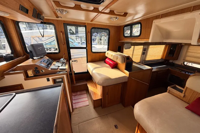 Nomad Yacht Photos Pics Cozy interior of a 2000 Nordic Tug 37 with wood accents and seating area.