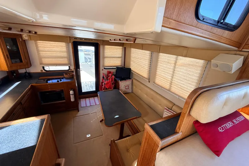 Nomad Yacht Photos Pics Interior of 2000 Nordic Tug 37, featuring cozy seating and a compact kitchen area.