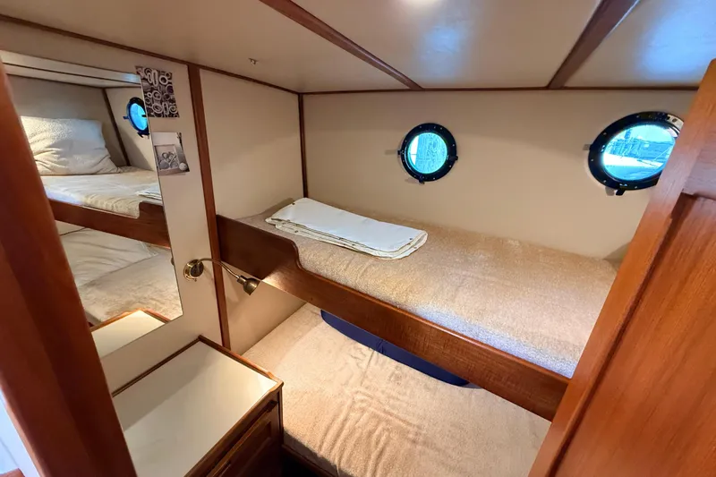 Nomad Yacht Photos Pics Cozy cabin interior of 2000 Nordic Tug 37 with bunk beds and porthole windows.