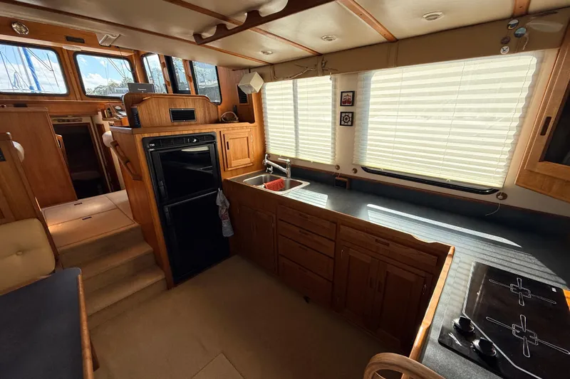 Nomad Yacht Photos Pics Interior of a 2000 Nordic Tug 37, featuring a cozy kitchen with wood cabinetry.