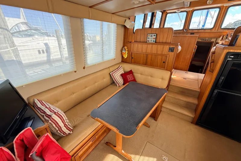 Nomad Yacht Photos Pics Interior of 2000 Nordic Tug 37 with cozy seating and wooden accents.