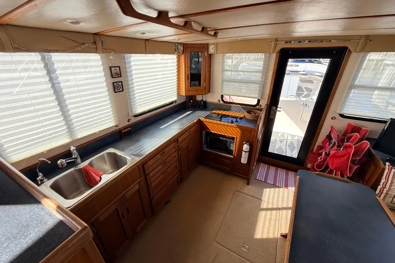 Nomad Yacht Photos Pics Interior of 2000 Nordic Tug 37, featuring a well-equipped kitchen with ample natural light.