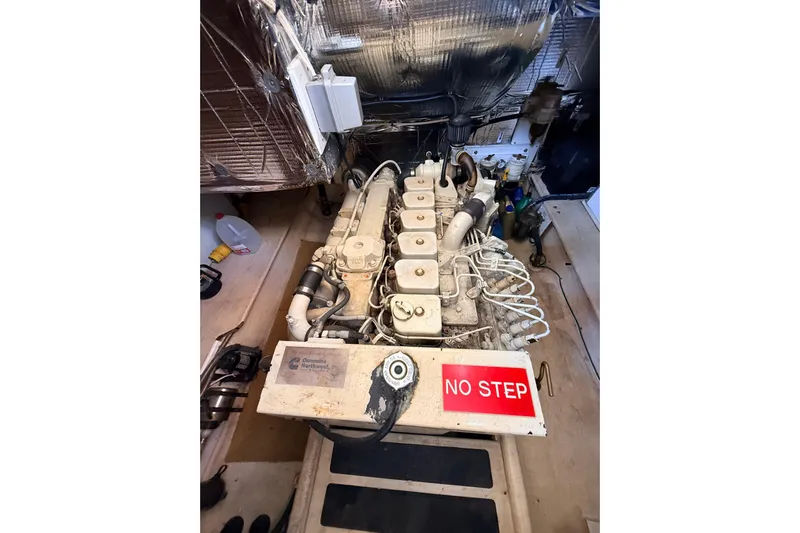 Nomad Yacht Photos Pics Engine room of a 2000 Nordic Tug 37 with Cummins engine and "No Step" warning sign.