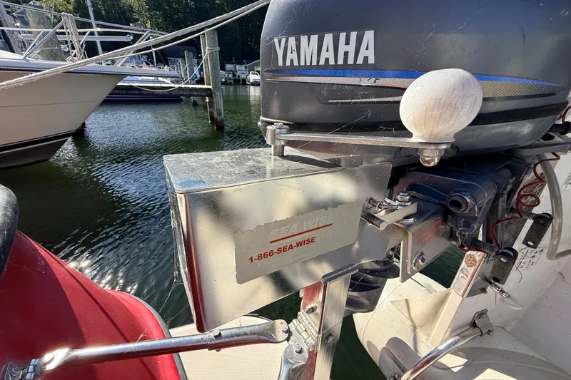 Nomad Yacht Photos Pics Outboard motor on a 2000 Nordic Tug 37, docked near water.