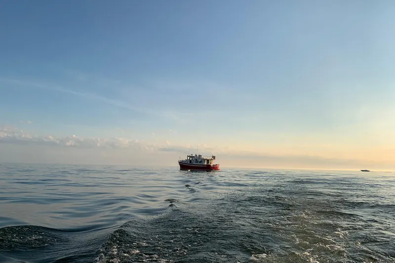 Nomad Yacht Photos Pics Nordic Tug 37 (2000) cruising on calm ocean at sunset.