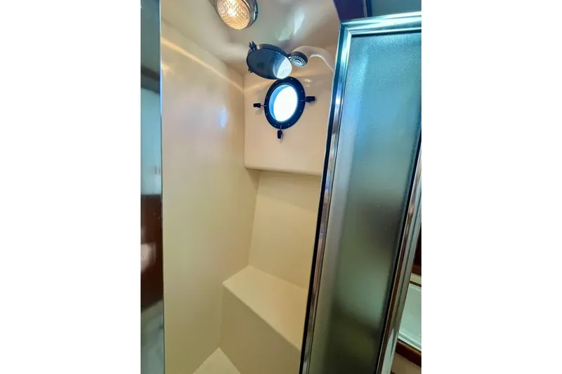 Nomad Yacht Photos Pics Interior of 2000 Nordic Tug 37 shower with porthole and light fixture.