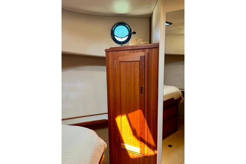 Nomad Yacht Photos Pics Interior of 2000 Nordic Tug 37 with wooden cabinet and porthole window.