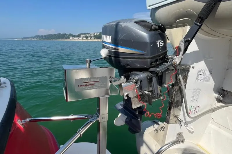 Nomad Yacht Photos Pics Outboard motor on a 2000 Nordic Tug 37, with scenic coastal background.