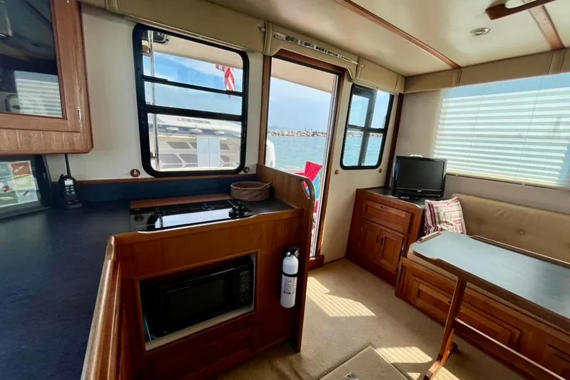 Nomad Yacht Photos Pics Interior of 2000 Nordic Tug 37 with kitchenette, seating, and ocean view.