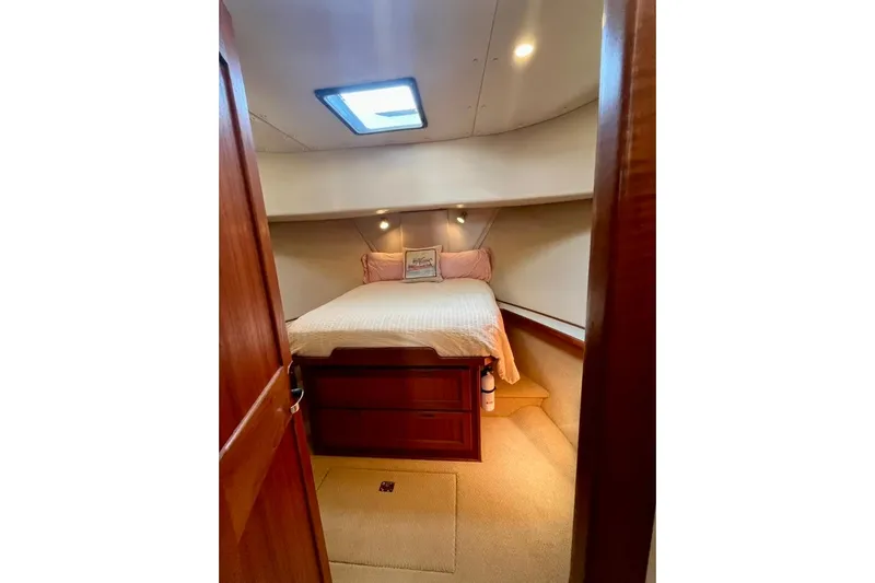 Nomad Yacht Photos Pics Cozy cabin interior of 2000 Nordic Tug 37 with bed and wooden furnishings.